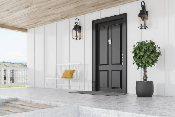 istock Black door of white house, tree, bench, side view 1185202817