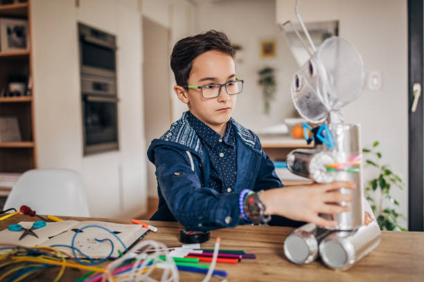 istock Boy making robot toy of recycling material 1185202822