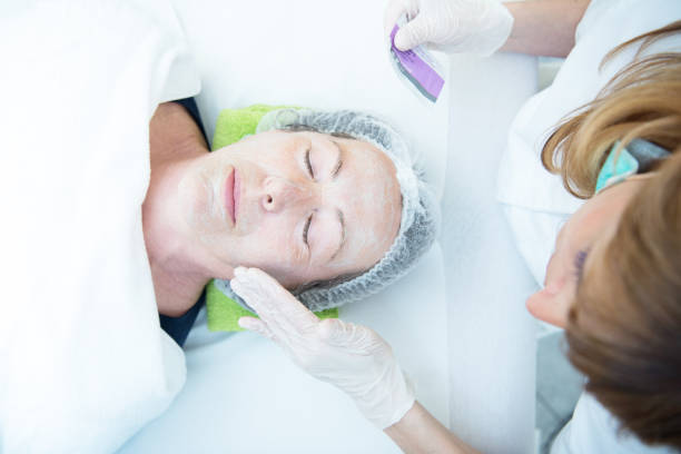 istock Beautician Applying Facial Mask 1185203689