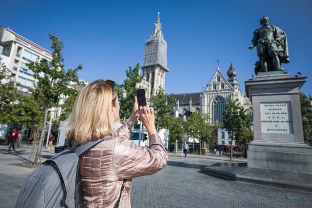 A happy elderly woman photographs the sights while travelling around a European city. stock photo