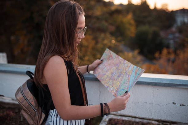 istock Woman tourist looking at city map 1185206411