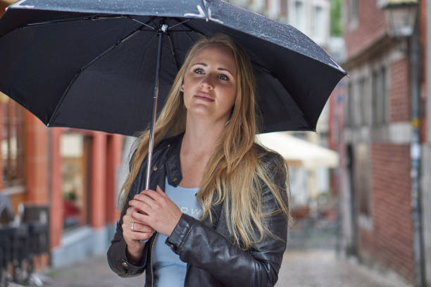 istock Cute blonde with umbrella in rain 1185207750