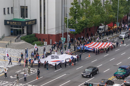 anti moon jae-in protesters marching down from gwanghwamun square in seoul south korea carry korean and usa flag. Taken in November 2nd, 2019.