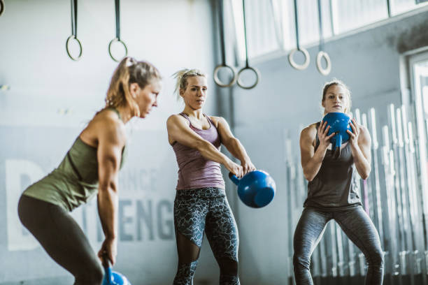 istock Young athletic women exercising with kettle bells in a gym. 1185208249