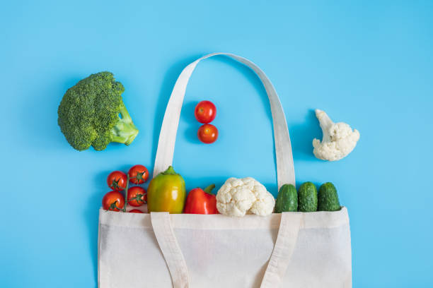 istock Zero waste concept. Vegetables in eco friendly reusable textile bag on blue background. Plastic free. Healthy fresh vegetarian food. 1185210196