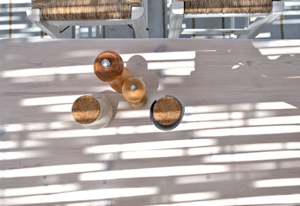 Sunlight and shadows on a table with peper, salt, oil and vinegar