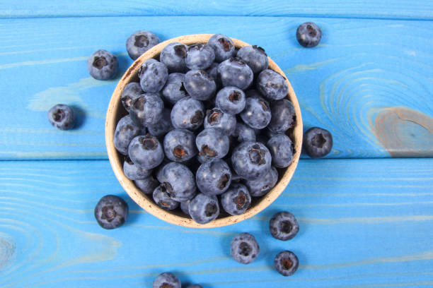 istock Raw fresh huckleberry in a bowl. Wooden background. 1185212323