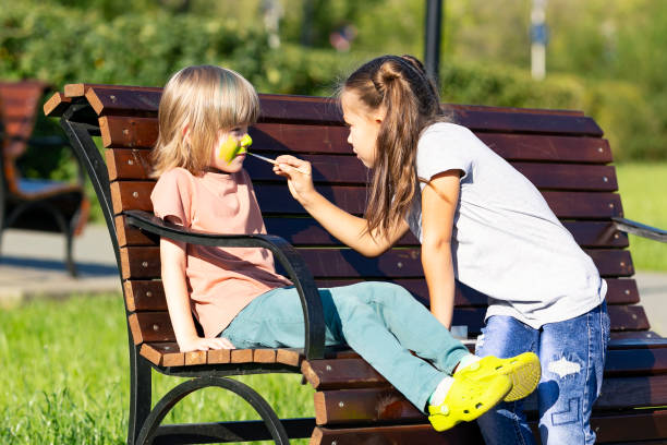 istock Sister paints on brothers face. 1185213326