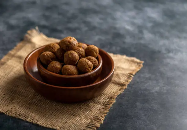 Coconut Laddoo with jaggery or Coconut Sweet Laddoo or Nariyal Laddu is a Popular Festival Food from India. Served over moody background, selective focus