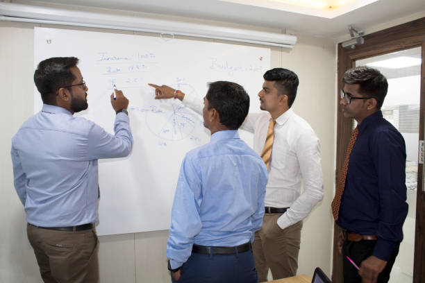 istock Business colleagues pointing at whiteboard in meeting 1185214927