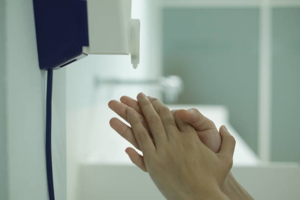 istock Hands under the automatic alcohol dispenser on the wall. 1185216336