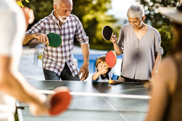 istock Happy extended family having fun while playing table tennis in the backyard. 1185217492