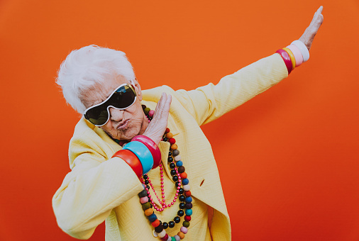 Divertidos retratos de abuelas. Anciana mayor vistiéndose elegante para un evento especial. abuela modelo de moda en fondos de colores photo
