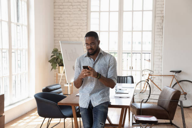 istock Concentrated african american manager scheduling meeting in mobile app. 1185220694