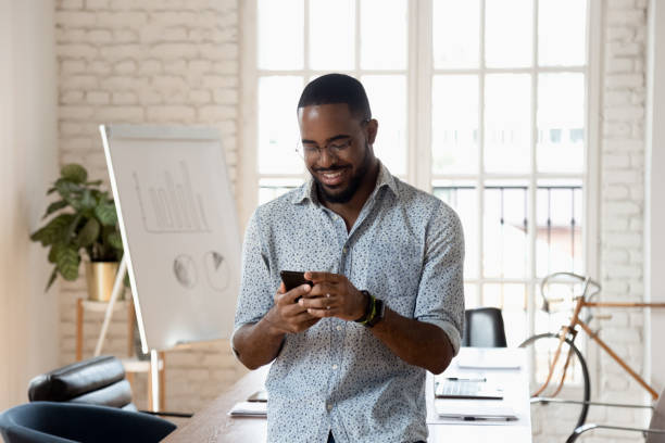 istock Happy mixed race young company worker texting message. 1185220697