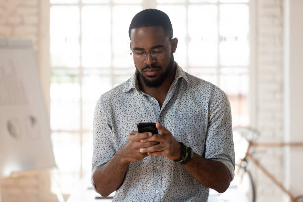 istock Serious african american young employee using smartphone. 1185220699
