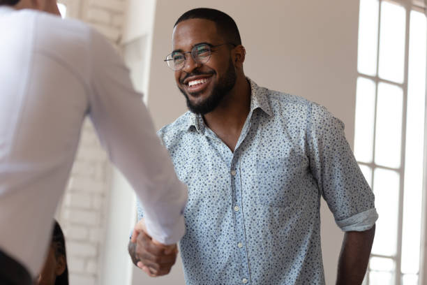 istock Joyful african american millennial worker shaking hands with colleague. 1185220736