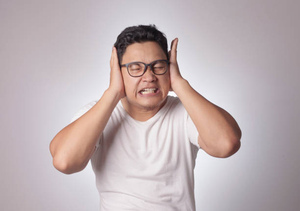 Young Man Close His Ears Dont Want to Hear Something Bad Portrait of young Asian man wearing casual white shirt closing his eyes and ears dont want or avoiding to hear bad news, stress under mental pressure concept man closing ears photos stock pictures, royalty-free photos & images