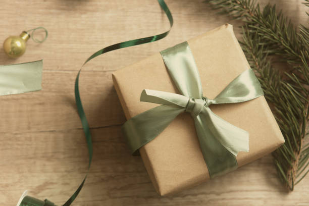 istock Gift box wrapped in craft paper with green ribbon 1185223526