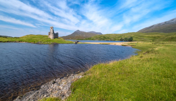 affascinanti rovine del castello di ardvreck in piedi su un promontorio roccioso che si protendono nel loch assynt a sutherland, highlands of scotland. - loch assynt foto e immagini stock
