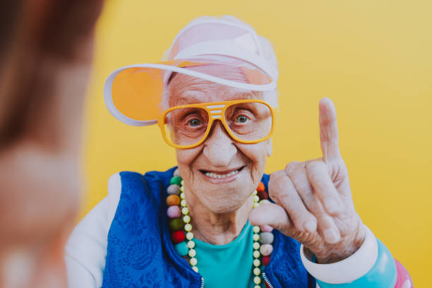divertenti ritratti della nonna. outfit in stile anni '80. trapstar scattando un selfie su sfondi colorati. concetto di anzianità e anziani - 1980s style image created 1980s 80 plus years music foto e immagini stock