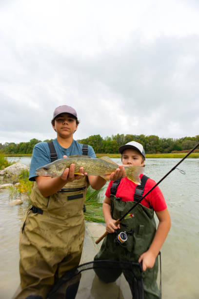 istock Two brothers with a pickerel or walleye fish they have caught. 1185229182