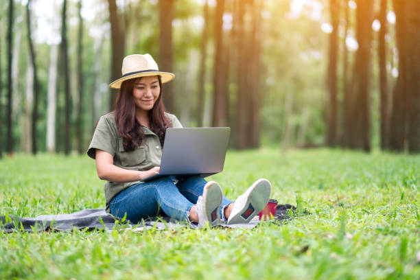 istock woman working and typing on laptop keyboard while sitting in the park 1185230290