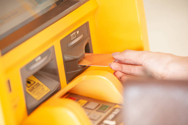 istock Young woman inserting a credit card to ATM 1185233175