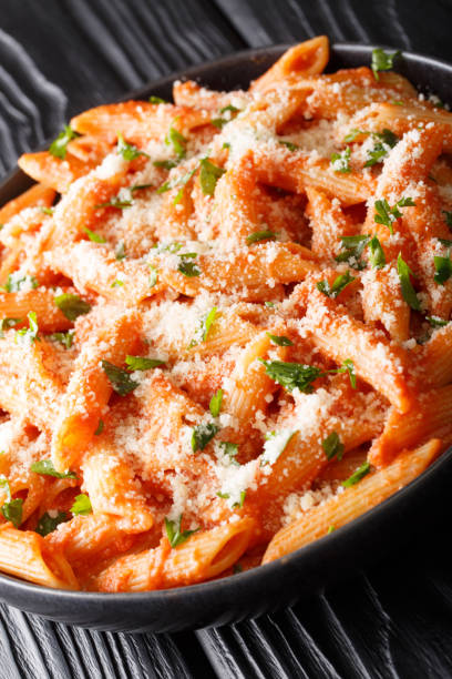 istock Penne alla vodka is a pasta dish made with vodka, usually made with heavy cream, crushed tomatoes, onions close-up on the table. Vertical 1185234743