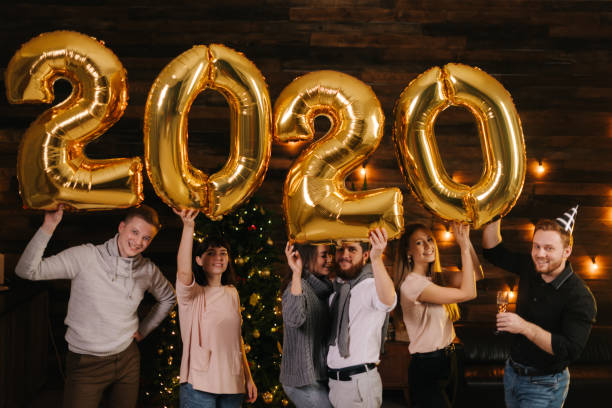 istock Three young happy couples are holding inflatable foil numerals 2020 1185236053