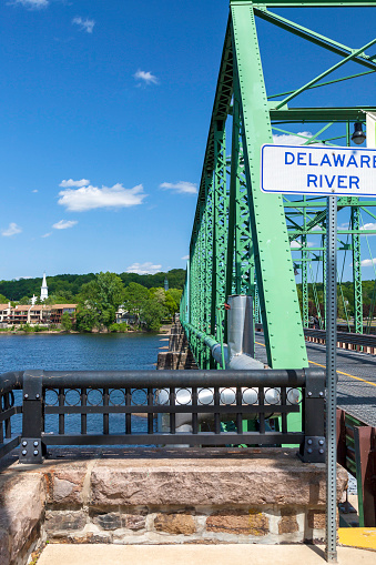 The Delaware River Bridge at New Hope, PA is over 1000 foot long and includes a pedestrian walkway.  It was built in 1904, thoroughly reconditioned in 2004, crosses to Lambertville, NJ.