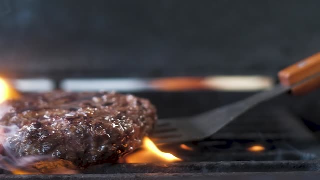 juicy meat for burgers overturned on a hot grill. Slow motion