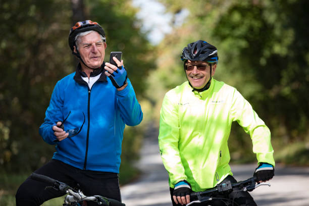 istock Smiling Senior Men Cycling Friends Using Mobile Phone 1185236456