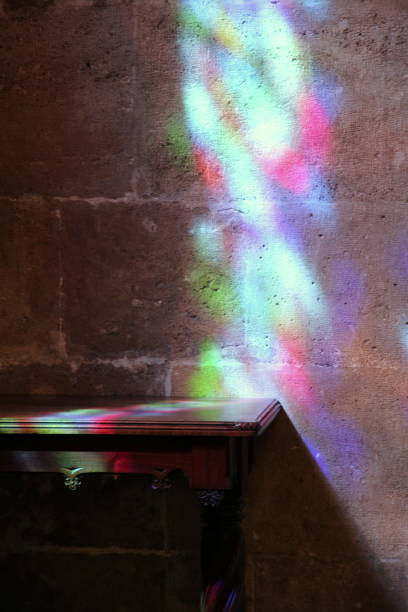 istock Multicolored reflections on the bare wall and on the old dark table 1185236507