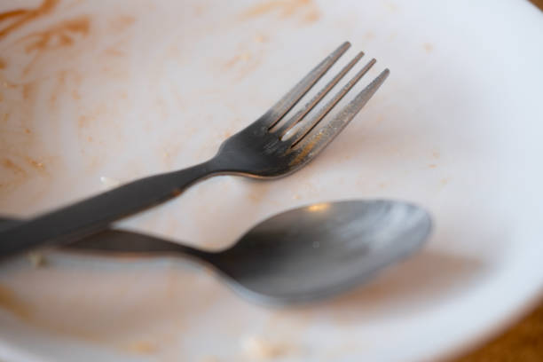 istock Dirty plate with spoon and fork after a meal. Close up 1185237845