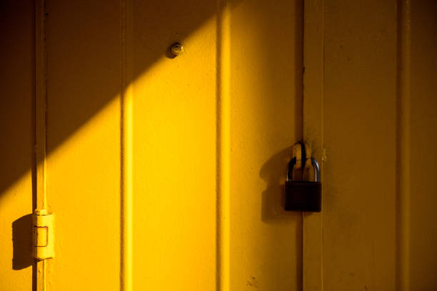 istock Brass padlock and yellow metal door 1185240252