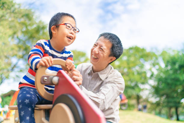 공원에서 아버지와 함께 즐기는 다운 증후군을 가진 아이 - 동아시아 문화 뉴스 사진 이미지