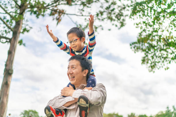istock Father carrying his son with down syndrome on his shoulders 1185240743