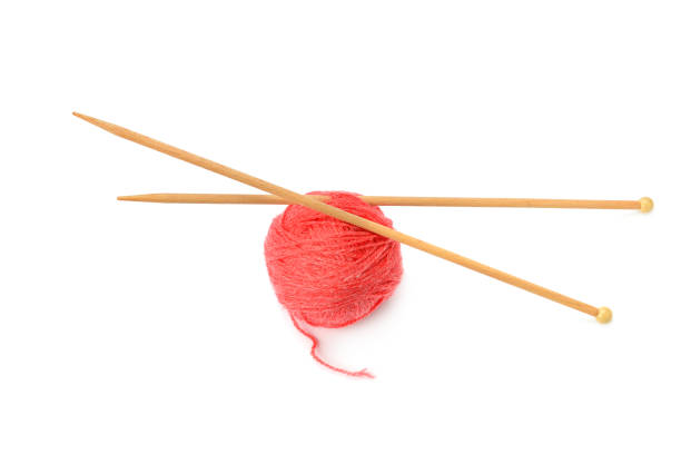 мяч из красной пряжи и вязание игл изолированы на белом фоне. - knitting needle стоковые фото и изображения