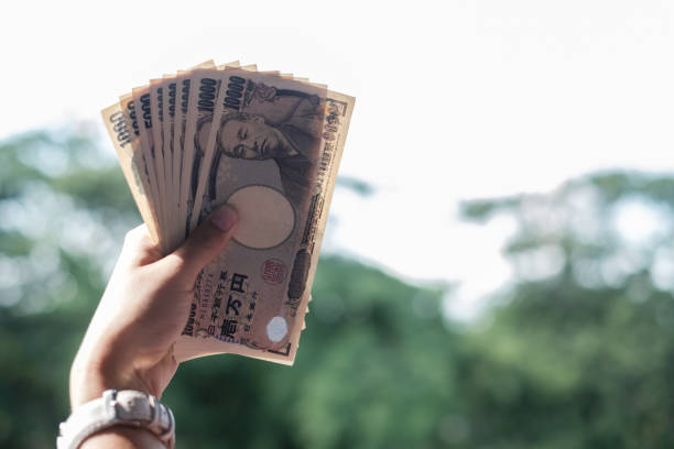 una mujer de negocios sosteniendo la pila de billetes de yenes japoneses. negocios, dinero, inversión, finanzas y conceptos de pago - banking bill women human hand fotografías e imágenes de stock