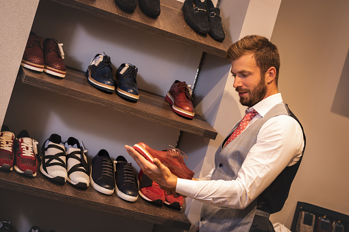 Young man are looking for a new shoes in the shoe shop