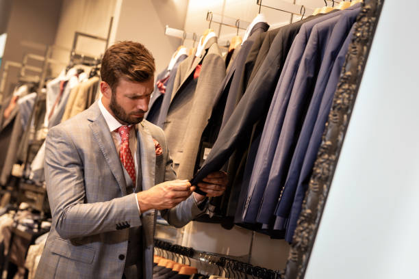 istock Elegant man in the clothes store looks declaration 1185242569