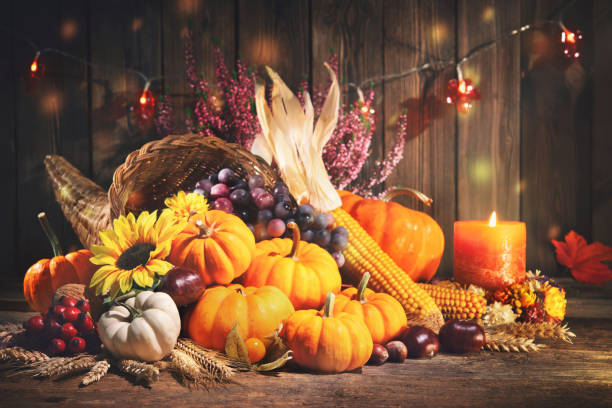 istock Pumpkins with fruits and falling leaves on rustic wooden table 1185245568
