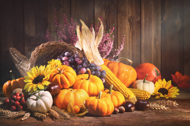 istock Pumpkins with fruits and falling leaves on rustic wooden table 1185245593