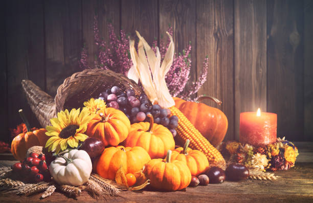 istock Pumpkins with fruits and falling leaves on rustic wooden table 1185245602