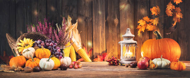 istock Pumpkins with fruits and falling leaves on rustic wooden table 1185245604
