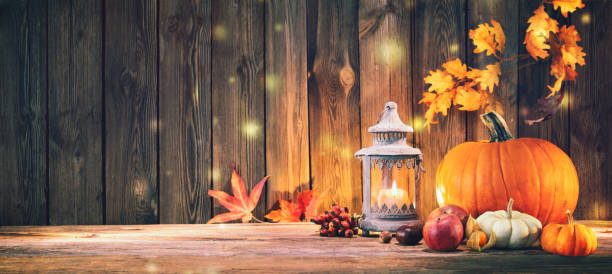 istock Pumpkins with fruits and falling leaves on rustic wooden table 1185245627