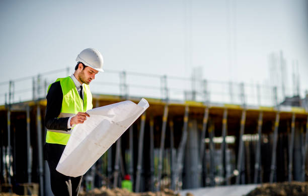 istock Side view of young construction engineer man with projects and hard hat 1185246329