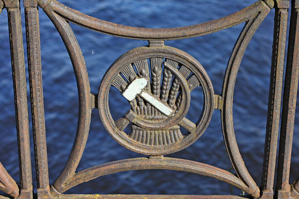 Riga, Latvia - 27 September 2014: Fragment of fence with a sickle, hammer and ears of corn