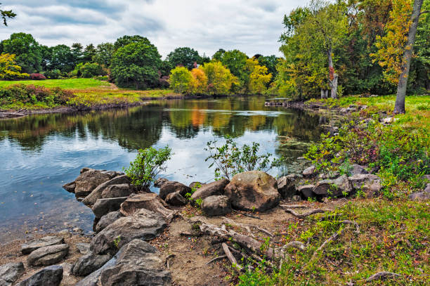 Concord River with Reflections in Massachusetts This colorful scenic view of the Concord River near the famed Old North Bridge the site of the beginning of the war for independence in America near Concord Massachusetts. concord massachusetts stock pictures, royalty-free photos & images